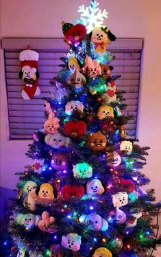 a christmas tree with many different stuffed animals on it's top and lights in the bottom