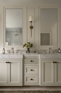 a white bathroom with two sinks and mirrors