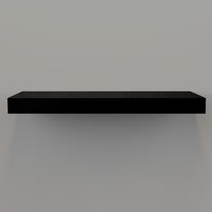 a black shelf sitting on top of a gray wall