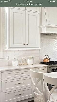 a kitchen with white cabinets and an island in the middle is featured on this page