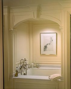 a bathroom with a tub, sink and mirror in it's center wall is shown