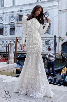 a woman in a white wedding dress standing next to a gondola