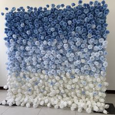 a large blue and white wall hanging on the side of a building with flowers all over it