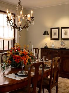 the dining room table is set with flowers and place settings for four people to sit at