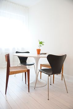 two chairs and a table in a white room