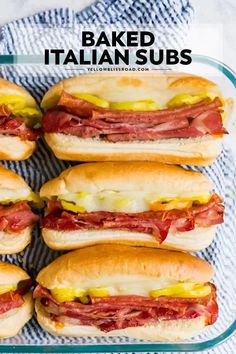 several sandwiches with meat and cheese on them sitting in a glass baking dish next to a blue towel