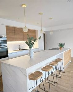 a kitchen with white counter tops and wooden stools