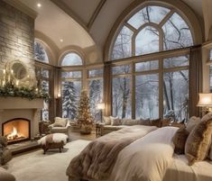 a large bedroom with a fireplace and lots of windows on the wall, along with two couches that are facing each other