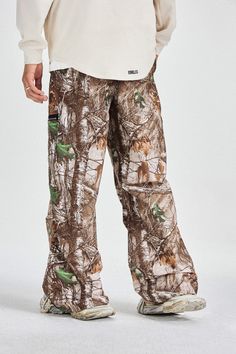 The Withered Leaves Crinkled Camo Cargo Pants are an outdoor leisure garment, featuring a camouflage pattern composed of tree branches and leaves. Dominated by brown and green tones, these pants are ideally suited for outdoor activities and casual wear. Fashion-forward and highly functional, they are perfect for individuals who enjoy outdoor adventures and appreciate natural scenery. The pants are designed with zippered pockets on the front, offering secure and convenient storage for personal it Camo Cargo Pants, Brown And Green, Outdoor Leisure, Natural Scenery, Green Tones, Outdoor Adventures, Male Model, Tree Branches, Outdoors Adventure