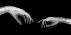 two hands reaching for each other in black and white