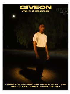 a man standing in the street at night with his hands on his hips, wearing black pants and a white t - shirt