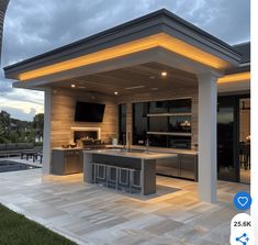 an outdoor kitchen is lit up at night with lights on the ceiling and countertop