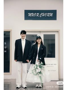 a man and woman standing in front of a building