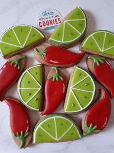 decorated cookies with green and red icing are arranged in the shape of fruits and vegetables