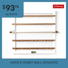 a white wall mounted shelf with three wooden shelves on it and the words hives & honey wall mounted above it