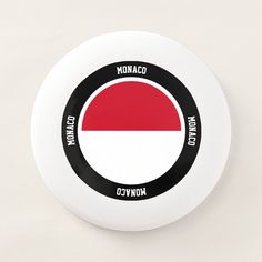 a white frisbee with a red, white and black circle on the front