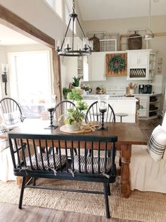 a dining room table with chairs and a bench in front of the kitchen counter area