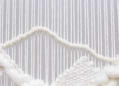 a close up view of a piece of white yarn on the side of a wall