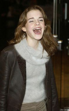 a woman laughing and wearing a leather jacket