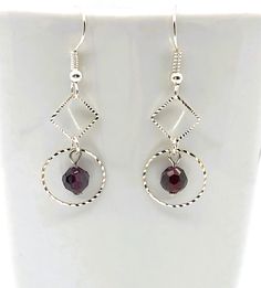 The laser cut detail on the silver-plated circles and diamonds give them an edgy look and have a purple glass bead dangle within the circle shape. The 1 3/4 inch earrings sway to your movement on a fishhook wire allowing the light to catch the laser cut on the silver plated shapes and the round faceted dark purple glass bead. They are secured with clear plastic backings. Details: - purple glass bead - silver-plated laser cut diamond and circle shape connectors - silver-plated fishhook wires - cl Purple Glass, Circle Shape, Creative Jewelry, Beaded Dangles, Cleaning Jewelry, Jewelry Plate, Diamond Shapes, Beaded Earrings, Violet