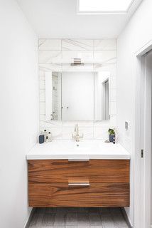 a bathroom with a large mirror above the sink and tiled flooring on the walls