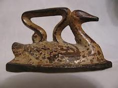 an old cast iron hook with two birds on it's sides, sitting on a white surface