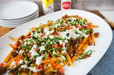 a white plate topped with fries covered in toppings