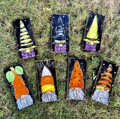 seven hand painted halloween gnomes are sitting in the grass