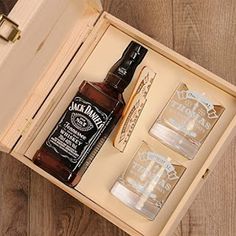 two shot glasses and an empty bottle in a wooden box