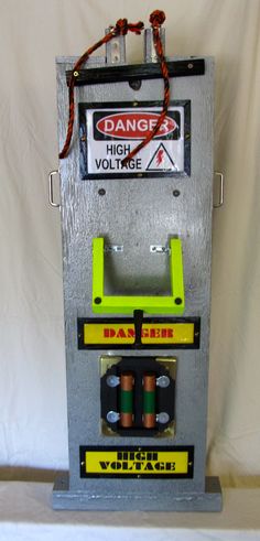 an old fashioned machine with two batteries on it's side and a danger sign attached to the back