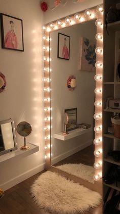 a mirror that has lights on it in front of a shelf with pictures and other items