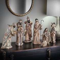 a group of figurines sitting on top of a table next to a mirror