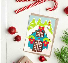 a christmas card with an image of a house and candy canes on the table