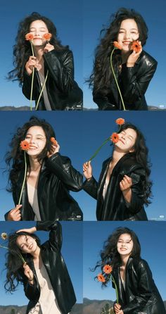 the woman is posing with flowers in her hand and holding it up to her face