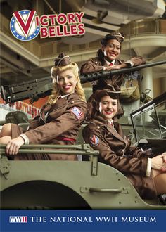 three women in uniforms are sitting on top of an army vehicle and posing for the camera