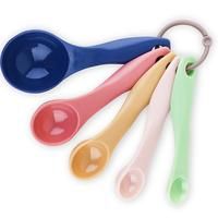 four spoons with different colored handles are shown