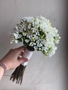 a hand holding a bouquet of white flowers