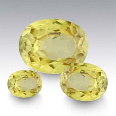 three yellow sapphires are shown on a white background and one is cut in half