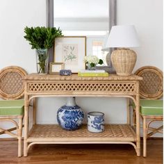 a table with two vases and a lamp on top of it next to a mirror