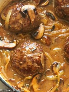 some meatballs and mushrooms are in a pot with noodles on the side, ready to be eaten