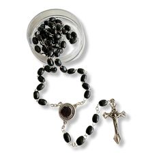 Discover a deeply spiritual treasure with this exquisite Saint Padre Pio black wooden rosary. Crafted with reverence and care, each bead is made from dark, lightweight wood that feels warm and comforting to the touch. The rosary's total length of 19 inches makes it both a substantial and portable item, perfect for prayer and meditation wherever you go. The centerpiece of this rosary is truly unique. It features a beautifully detailed image of Saint Padre Pio on the front, inviting a deep connect Black Crucifix Rosary As Gift, Black Crucifix Rosary Bracelet As Gift, Black Spiritual Rosary Bracelet With Cross, Black Wooden Beads Rosary Spiritual Style, Black Wooden Beads Spiritual Rosary, Black Wooden Beads Rosary, Wooden Rosary, Pope Benedict, Pray For Us