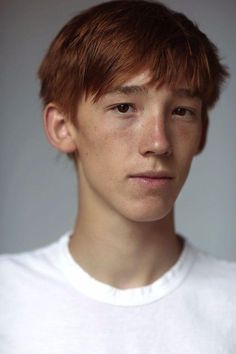 a close up of a person wearing a white t - shirt and looking at the camera