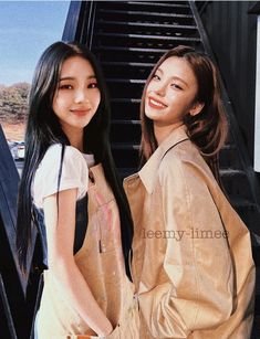 two young women standing next to each other on the side of a flight of stairs