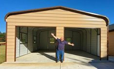 a man standing in front of a garage with his arms out and one hand up