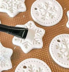 some snowflakes are being made on a tray with a black paint brush in the middle