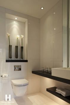 a modern bathroom with white tile and black accents