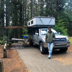 a man standing in front of a truck with a camper on it's back