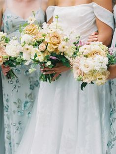 the bridesmaids are holding their bouquets together