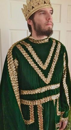 a man in a green and gold costume with a beard wearing a crown on his head