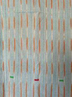 an orange and white striped fabric with green dots